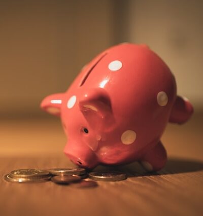 pink piggy bank tipped over spilling change on a table