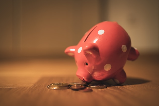 pink piggy bank tipped over spilling change on a table